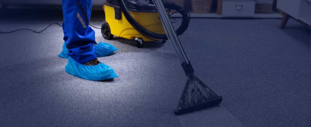 About us - employee cleaning carpet with equipment